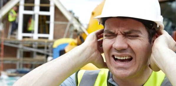 Ein Bauarbeiter hält sich die Ohren zu