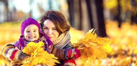 Mama mit Kind im Herbstlaub