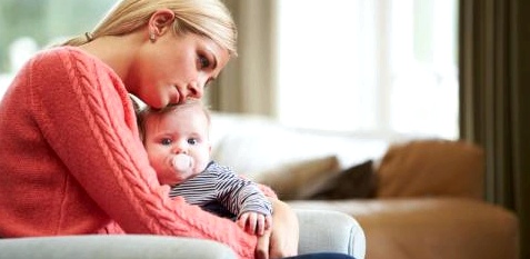 Eine Mutter hält ihr Baby im Arm und schaut nachdenklich
