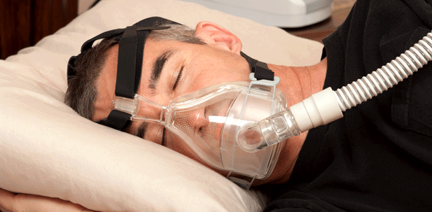 Ein Mann schläft mit Atemmaske