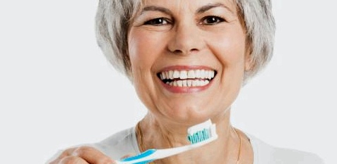 Eine ältere Frau putzt sich die Zähne