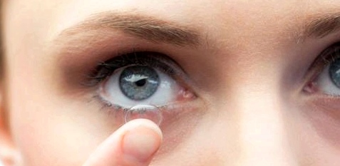 Eine Frau setzt sich Kontaktlinsen ein