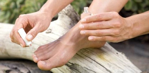 Frau lackiert sich die Fußnägel mit medizinischem Lack