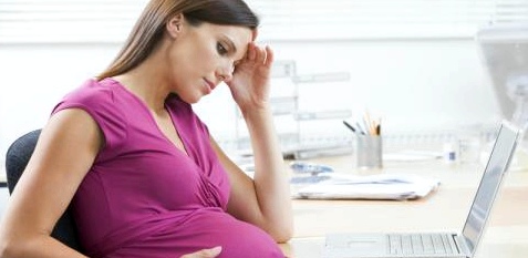 Eine Schwangere arbeitet am Computer