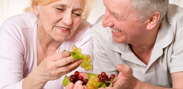 Ein älteres Pärchen isst Trauben