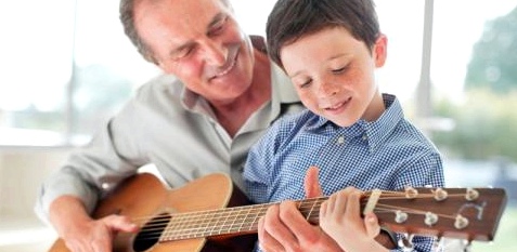 Opa spielt mit Enkel Gitarre