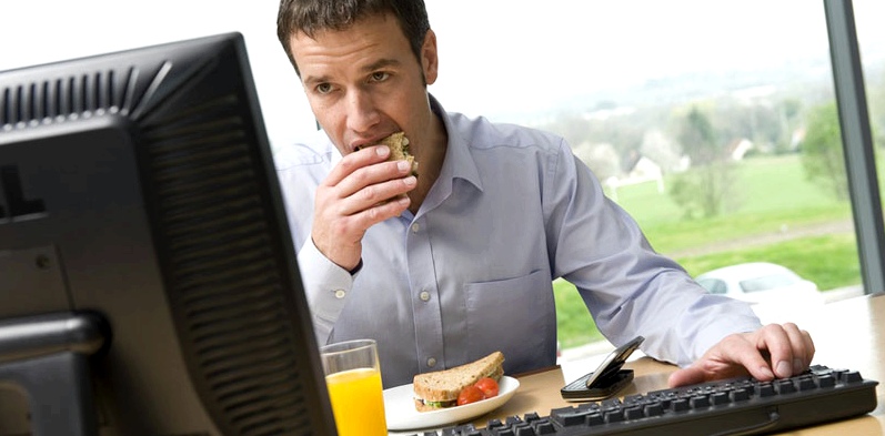 Mann isst während der Arbeit