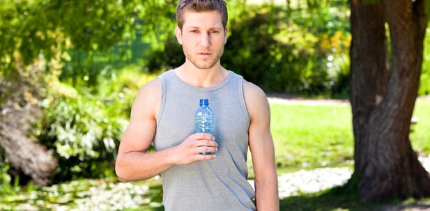 Ein Sportler hält eine Wasserflasche in der Hand